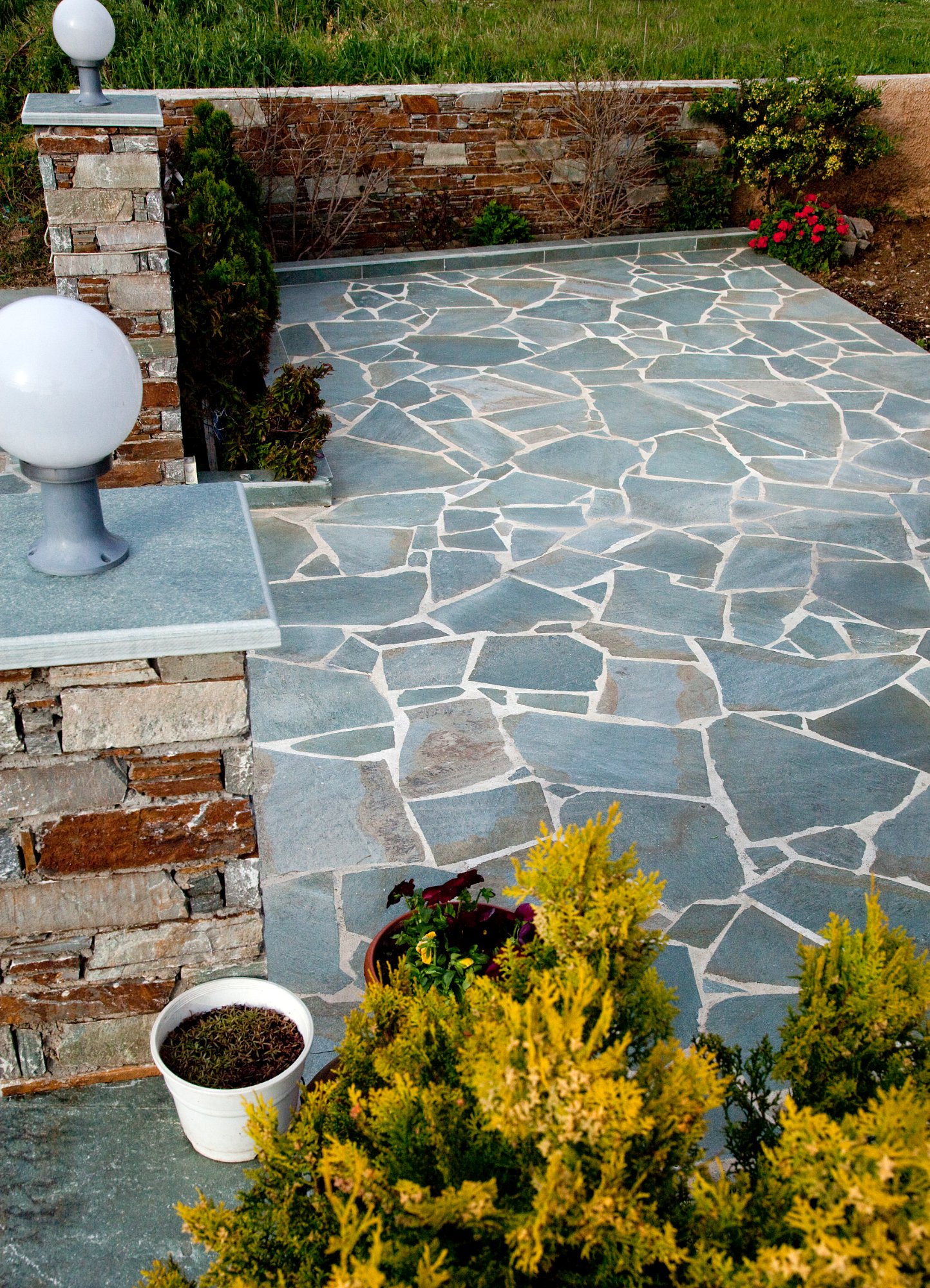 Ακανόνιστες πλάκες Καρύστου σε δάπεδο κήπου με αγκωνάρι